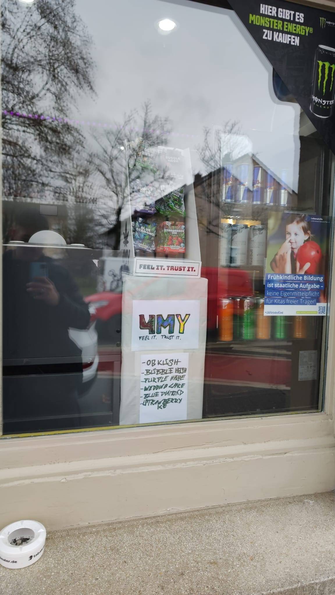 Cannabinoid Shop im Schaufenster Ein 4MA Produktaufsteller im Schaufenster, wo drunter das Logo von 4MY mit der Hand und unterschiedlichen Farben gemalt ist