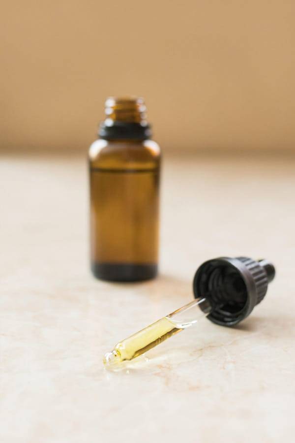 CBD Öl Flasche mit Pipette als Darstellung von Reinheit und Konzentration Offene CBD Öl Flasche mit Pipette auf neutralem Untergrund als sachliche Darstellung von Konzentration und Produktreinheit