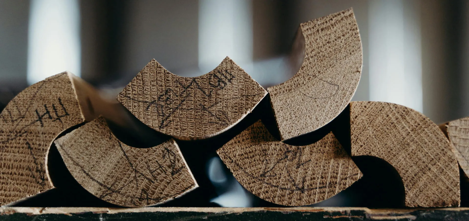 Gestapelte halbrunde Holzelemente als Symbolbild für HHC und die Veränderung im Markt halbsynthetischer Cannabinoide