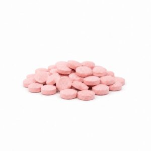 Rosafarbene runde Tabletten als kompakter Stapel auf weißem Hintergrund