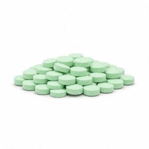 Mintgrüne runde Tabletten als kompakter Stapel auf weißem Hintergrund