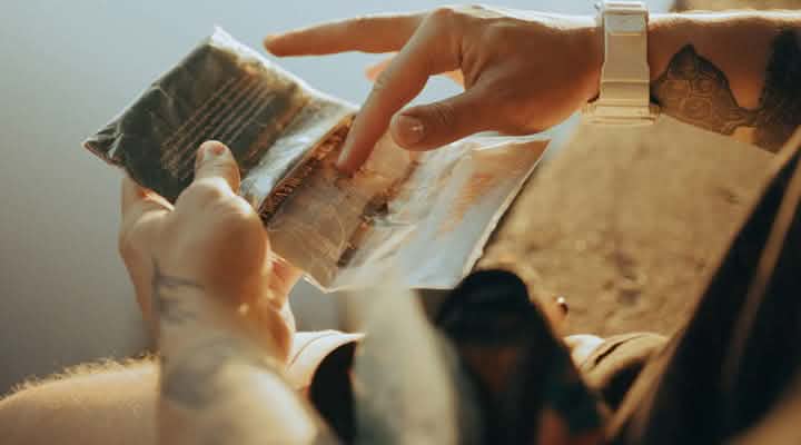 Person betrachtet eine transparente Produktverpackung mit aufgedruckten Angaben